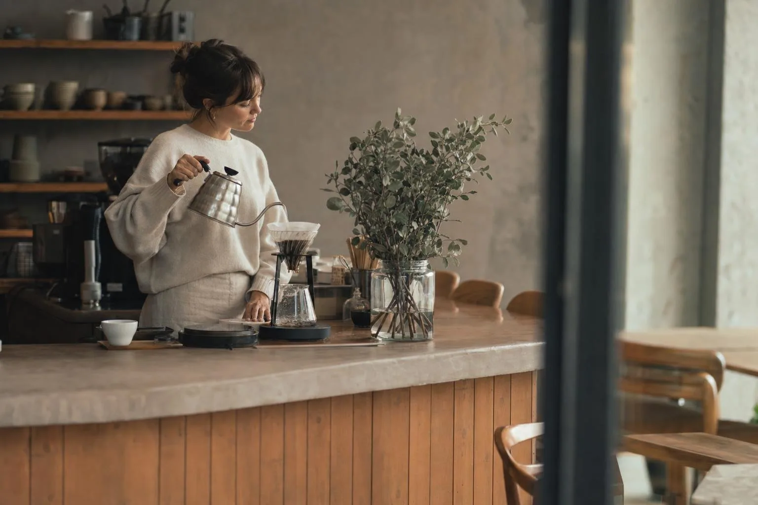 Warm cafe interior with a coffee bar and pastries on the counter